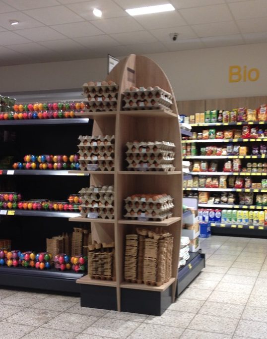 Referenzen Tischlerei Sudhoff – Eierregal im Ladenbau mit eiförmiger Präsentation