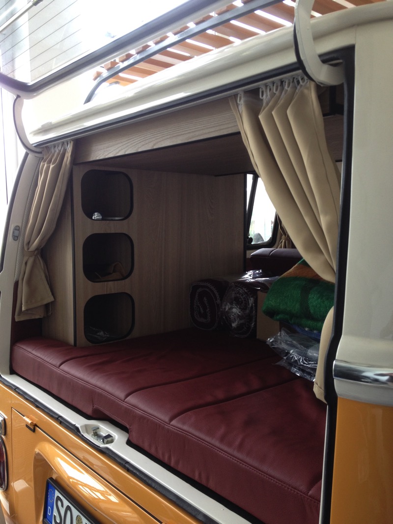 VW T2 Innenraum – Blick durch die Heckklappe auf Hochschrank und Leder-Liegefläche