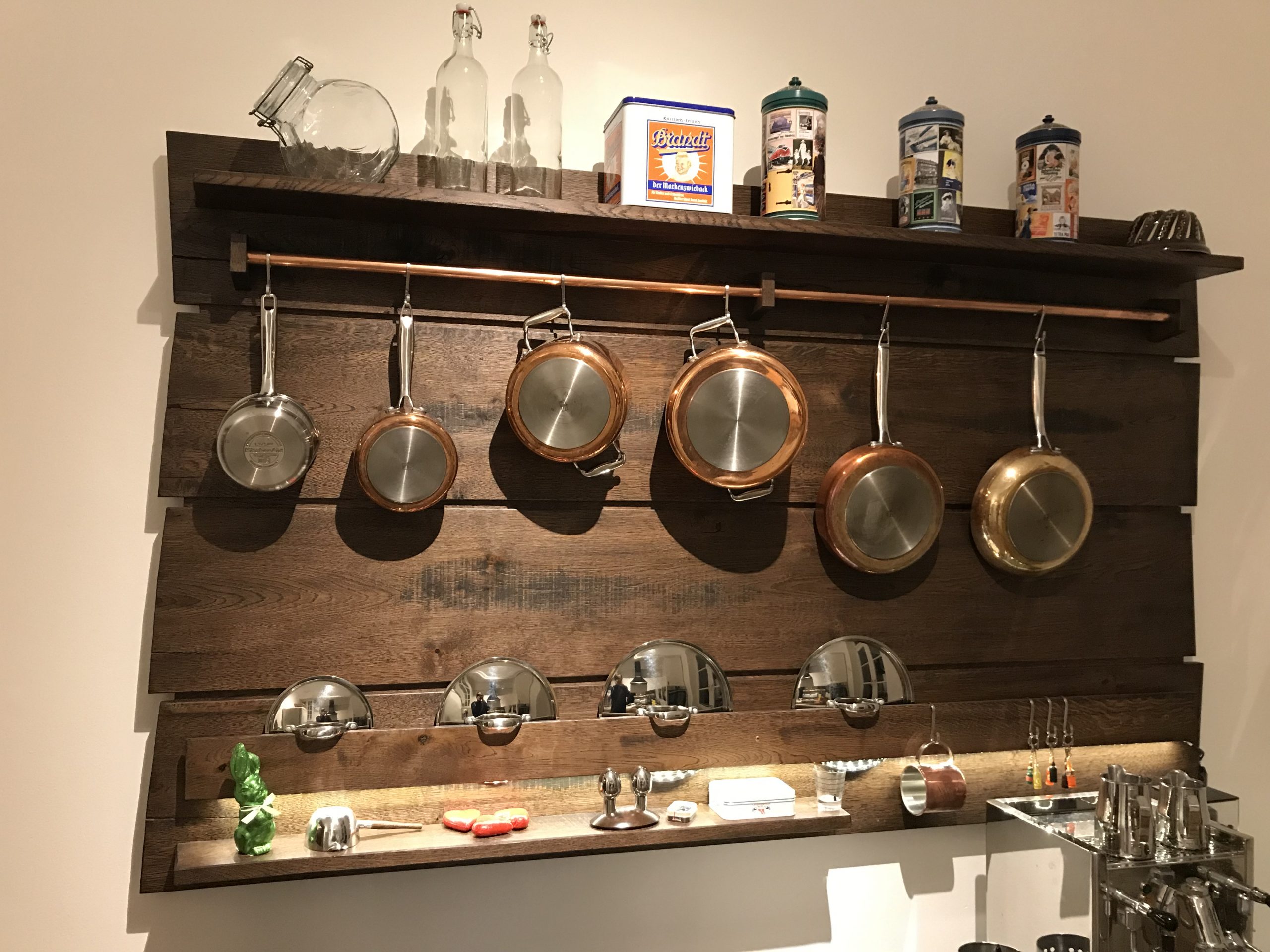 Frontalansicht des Küchenregals aus Eiche mit Kupferstange und Kupfertöpfen in einer Küche in Werl